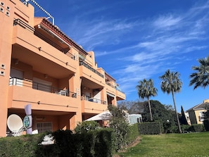 A multi-story building with balconies, a satellite dish, and a well-maintained lawn. - IDEAL FOR FAMILY HOLIDAYS (AN)