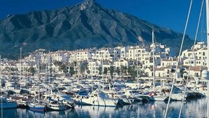 A marina with numerous boats docked, a mountainous backdrop, and a densely packed town with white buildings. - IDEAL FOR FAMILY HOLIDAYS (AN)