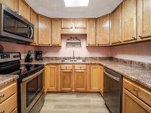Enjoy cooking in this well-equipped kitchen with a microwave, oven, sink, and coffee maker.