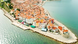 A coastal town with buildings along the waterfront, a pier, and a tower. - Villa Lavanda in Kriz Sezana With Private Swimpool (Sezana)