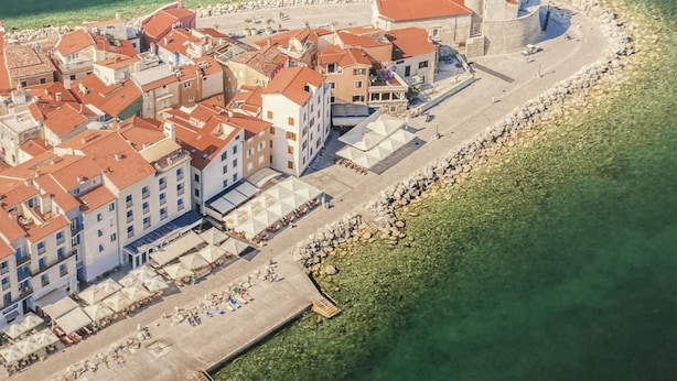An aerial view of a coastal town with buildings, a promenade, and a tower. - Villa Lavanda in Kriz Sezana With Private Swimpool (Sezana)