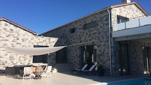 A stone building with a pool, outdoor seating, and a clear blue sky. - Villa Lavanda in Kriz Sezana With Private Swimpool (Sezana)