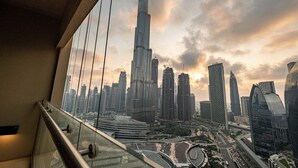 Un immeuble de grande hauteur doté d’une balustrade en verre et offrant une vue sur le paysage urbain.