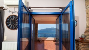 A balcony with a view of the sea, a clock, and a radiator.