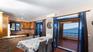 A kitchen with wooden cabinets and a dining area with a table set for two.