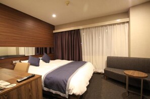 Relax in comfort with a large bed, sofa, and TV for a cozy retreat.