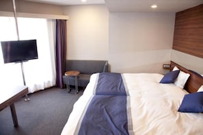 Relax in comfort with a large bed, flat-screen TV, and a convenient table and chair.