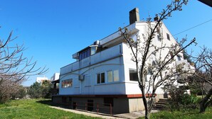 A modern two-story building with a flat roof, large windows, and a visible chimney. - Modern apartment Tomislav 1 on the island of Krk (Malinska)