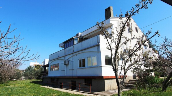 A modern two-story building with a flat roof, large windows, and a visible chimney.