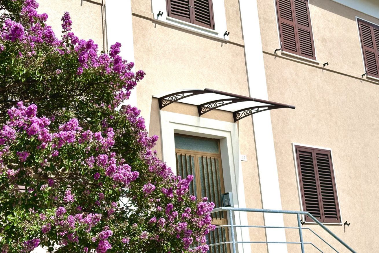 A building with a balcony, a door, and shutters.