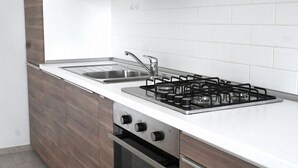 A modern kitchen with a gas stove, sink, and oven. - M272 - Marcelli, new three-room apartment with garden (Marcelli)