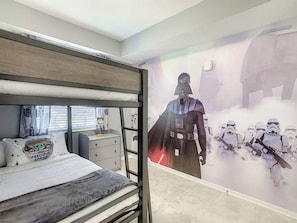 En køjeseng med en vægmaleri med Star Wars-tema.
