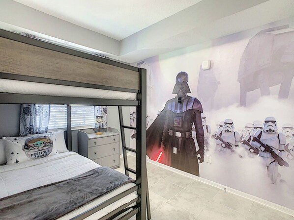 A bunk bed with a Star Wars-themed wall mural.