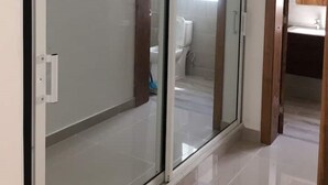 Een moderne badkamer met een douchecabine van glas, een toilet en een wastafel.