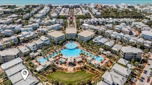 Ein Luftbild eines Resorts mit mehreren Gebäuden, einem zentralen Schwimmbecken und Blick auf den Ozean.