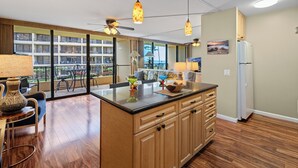 A spacious kitchen with wooden cabinets, a central island, and pendant lighting.