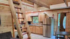 Eine moderne Küche mit Holzausstattung, einem Edelstahlkühlschrank und einer Holztreppe.