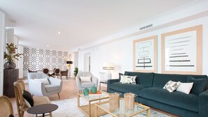 A modern living room with a green sofa, two armchairs, a coffee table, and a patterned rug. - Genteel Home Madrazo IV Terrace (Madrid)