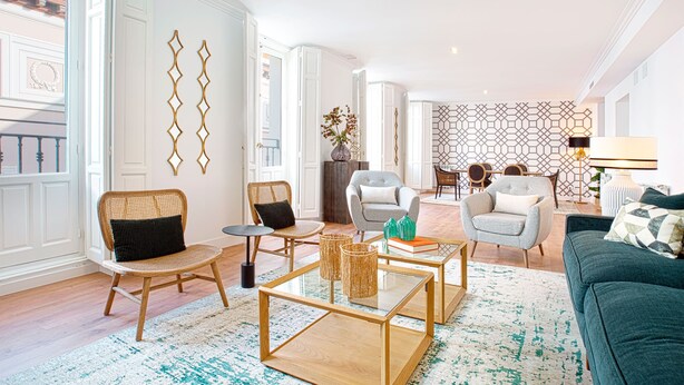 A spacious living room with a large green sofa, two armchairs, a coffee table, and a dining area in the background. - Genteel Home Madrazo IV Terrace (Madrid)
