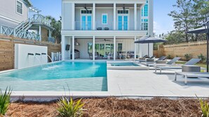 Une maison à deux étages dotée d’une piscine, d’un espace extérieur aménagé et d’un patio couvert.