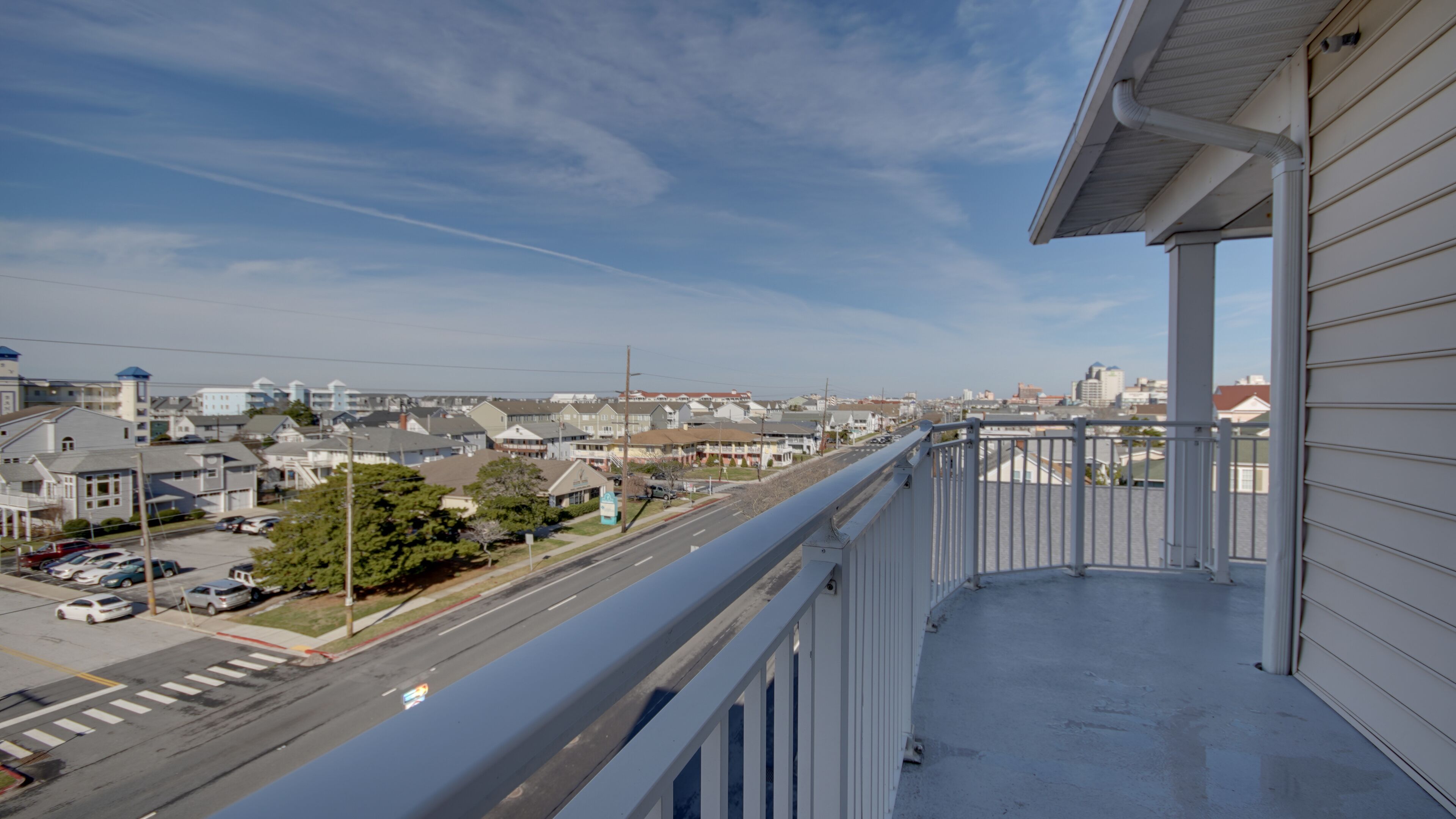Un balcón con vista a una calle residencial y edificios.