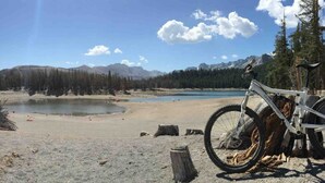 A mountain landscape with a lake, a bicycle, and a wooden post. - EV Charging. Private garage in town by restaurants (Mammoth Lakes)