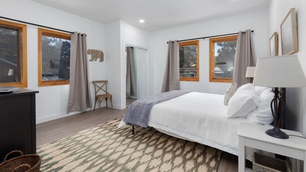 Une chambre à coucher avec un lit, une chaise, un bureau et une lampe.