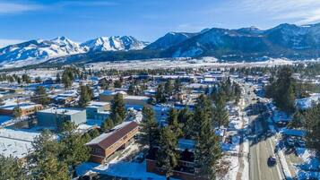 A town with buildings, roads, and snow-covered mountains in the background.