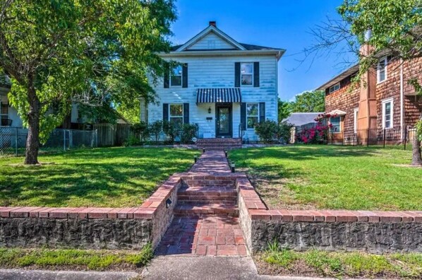 Traditional home with a charming front porch and beautifully manicured lawn.