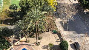 An aerial view of a swimming pool surrounded by palm trees and a basketball court. - Cristian's Apartment 2 (Benidorm)