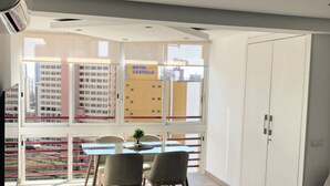 A modern hotel room with a dining area, a sofa, and a view of the cityscape. - Cristian's Apartment 2 (Benidorm)
