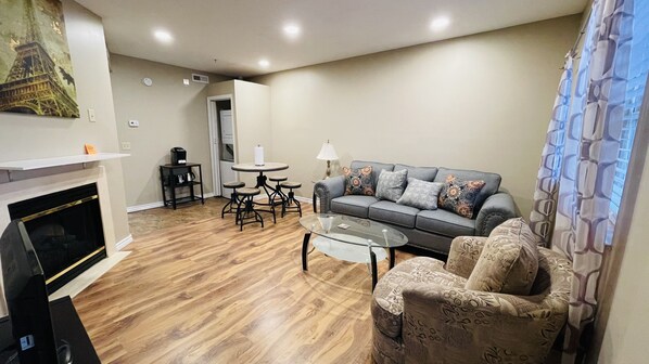 Cozy living space with a fireplace, sofa, coffee table, and armchair. Enjoy meals at the dining area with a small table and chairs.