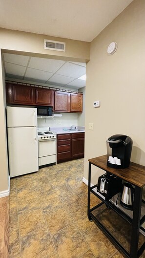 Enjoy cooking in this well-equipped kitchen with a refrigerator, stove, microwave, and coffee maker.