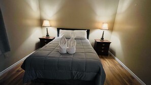 Relax in a spacious room with a large bed, two nightstands, and soft lighting.