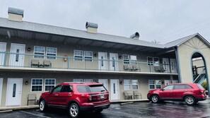 Two-story motel with a flat roof and balcony, featuring windows on each floor and ground-floor doors.