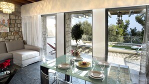 Zona de menjador moderna amb taula de vidre, plats blancs i copes de vi.