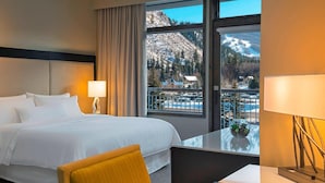 A hotel room with a bed, a chair, a desk, a lamp, and a large window offering a mountain view. - The Westin Riverfront Resort & Spa, Avon, Vail Valley (Avon)