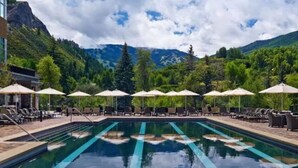 A swimming pool with lounge chairs and umbrellas, surrounded by mountains and trees. - The Westin Riverfront Resort & Spa, Avon, Vail Valley (Avon)