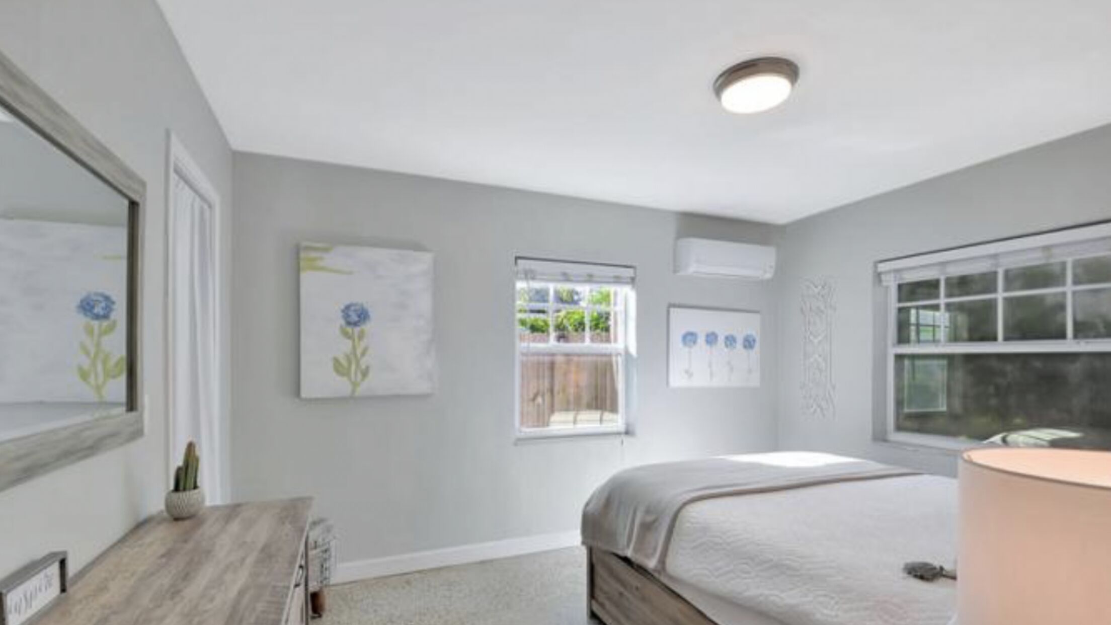 Un dormitorio con cama, escritorio, silla, ventana y lámpara de techo.