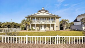A two-story house with a front porch, a balcony, and a garage.