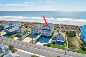 A coastal residential area with beachfront properties, a road, and a beach.