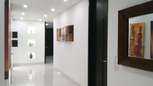 A hallway with a polished floor, recessed lighting, and artwork on the walls. - Luxury apartment playa azul cartagena 200m² (La Boquilla)