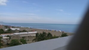 A coastal view with a beach, buildings, and a clear sky. - Luxury apartment playa azul cartagena 200m² (La Boquilla)