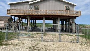 A two-story house with a balcony, a fenced yard, and a gravel driveway. - Paradise on the Bayou at the Bat Cave! (Slidell)