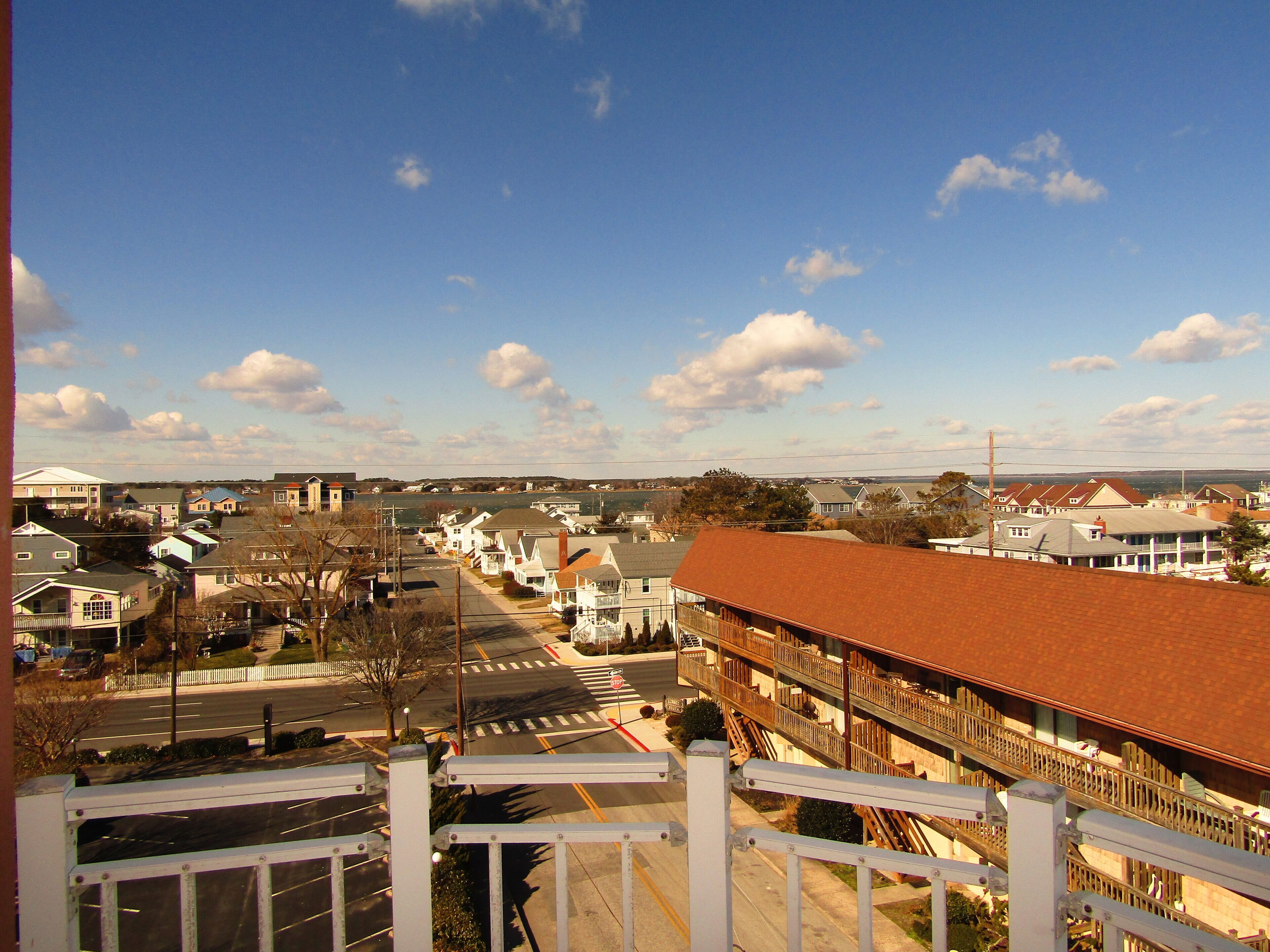 A residential area with houses, a street, and a train station in the background.