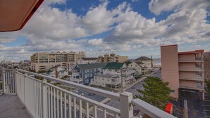A coastal residential area with multi-story buildings, a clear sky, and a view of the ocean. - Americana Princess Suites and Condos (Ocean City)