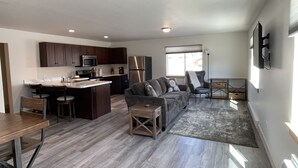 A spacious living area with a kitchen, a sofa set, and a dining table.