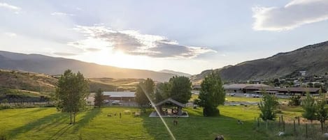 A rural landscape with a gazebo, open fields, and distant hills.