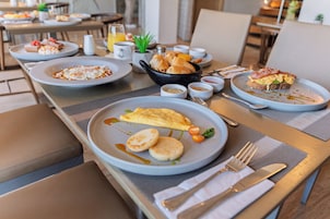 Un bufé de desayuno con diversos platos y una zona de estar.