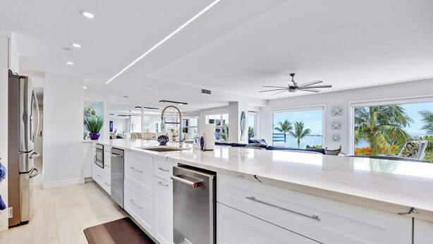 A modern kitchen with white cabinetry, a dishwasher, and a large island. - Sublime Sunsets at the Truman Annex in Key West (Key West)